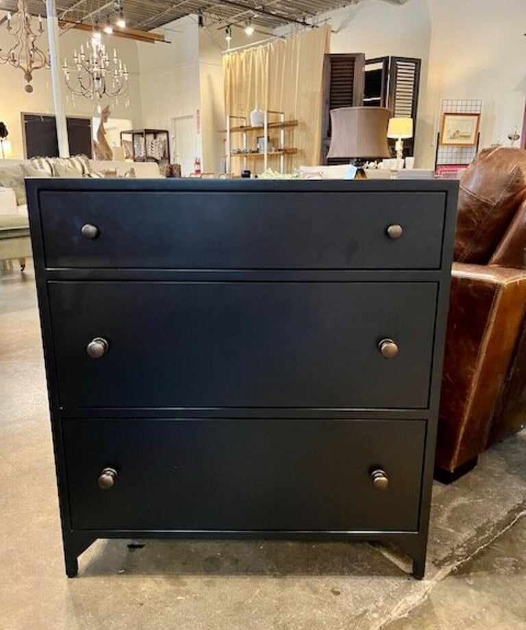 Modern black three-drawer dresser in contemporary living room with leather chair