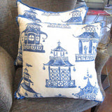 Designer fabric pillows with blue pagoda prints on gray armchair in furniture store